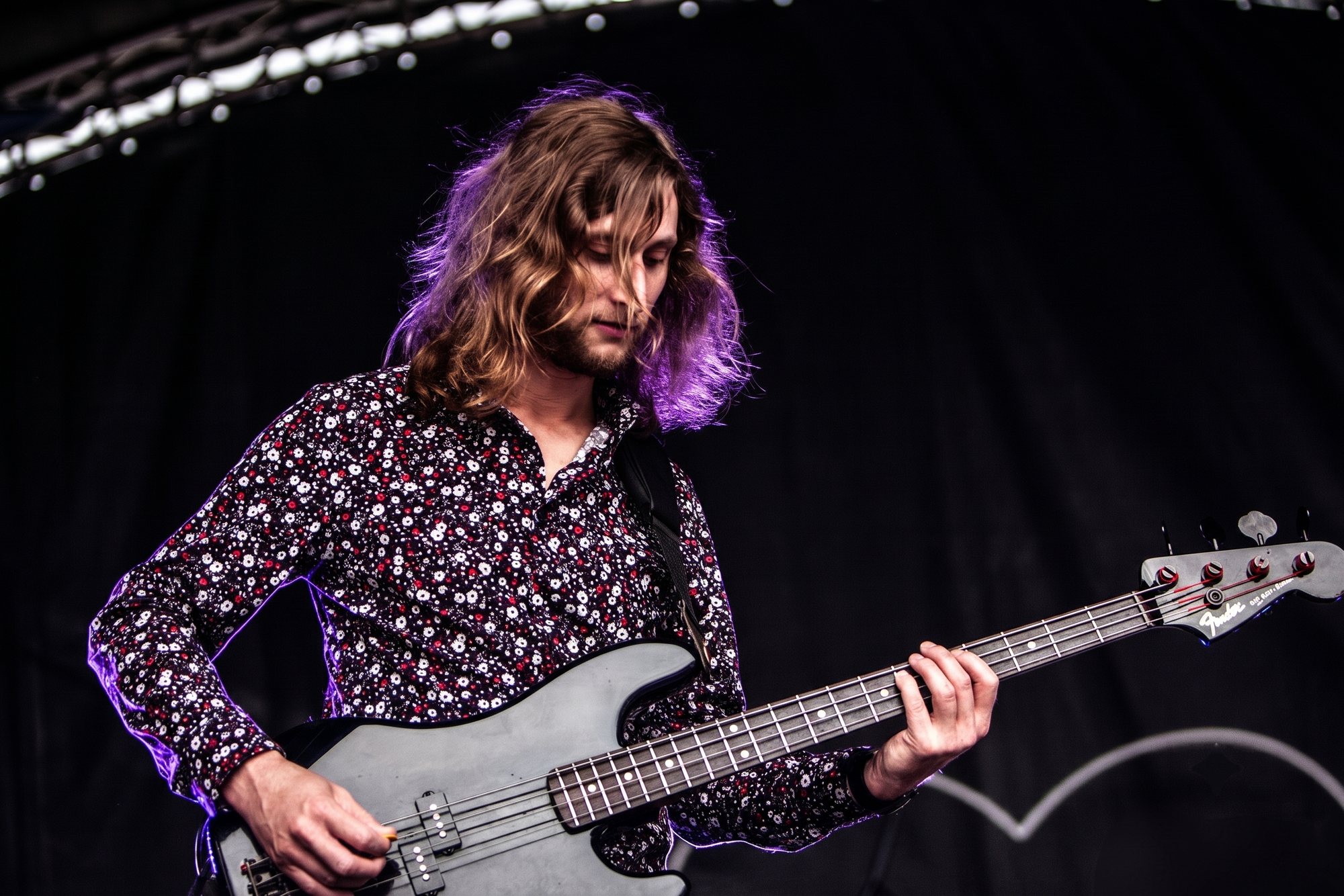 Freddie playing bass under stage lights